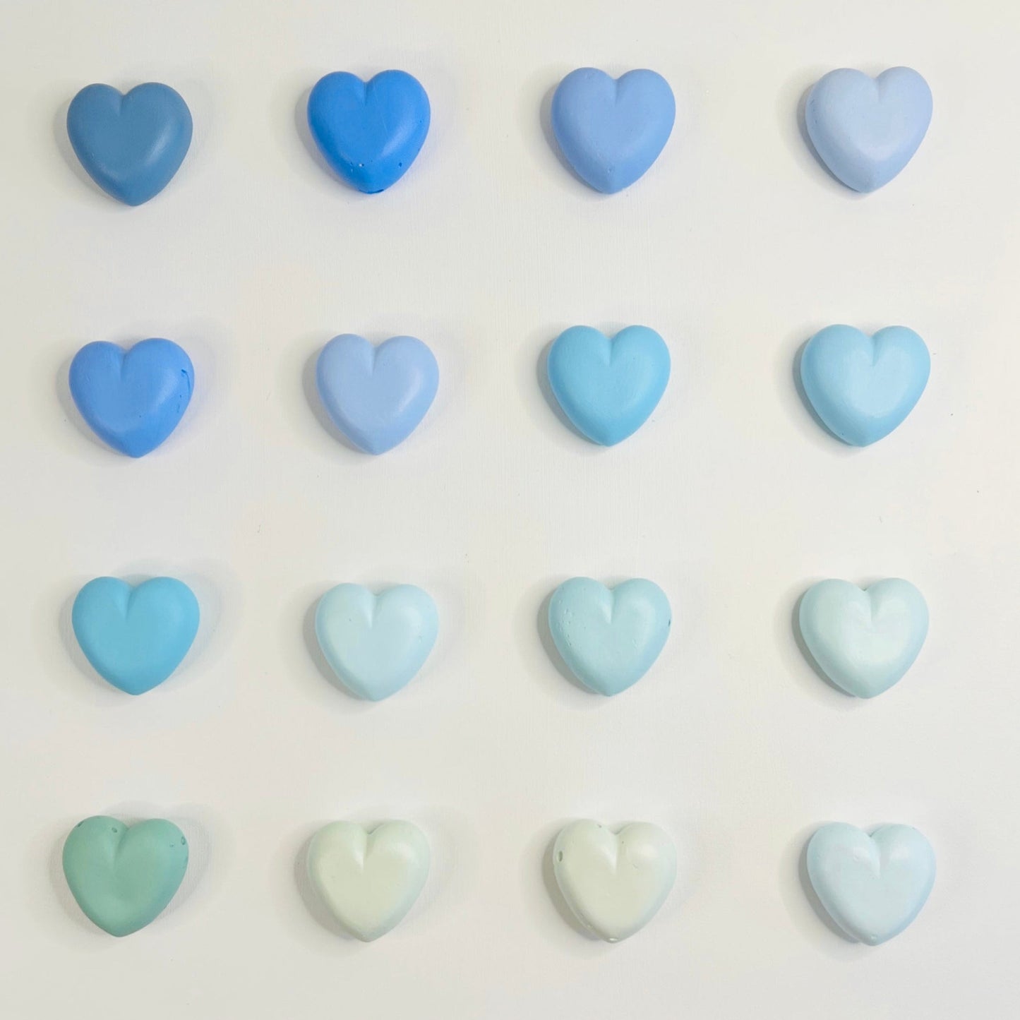 Pastel blue and green heart-shaped candies on a white background