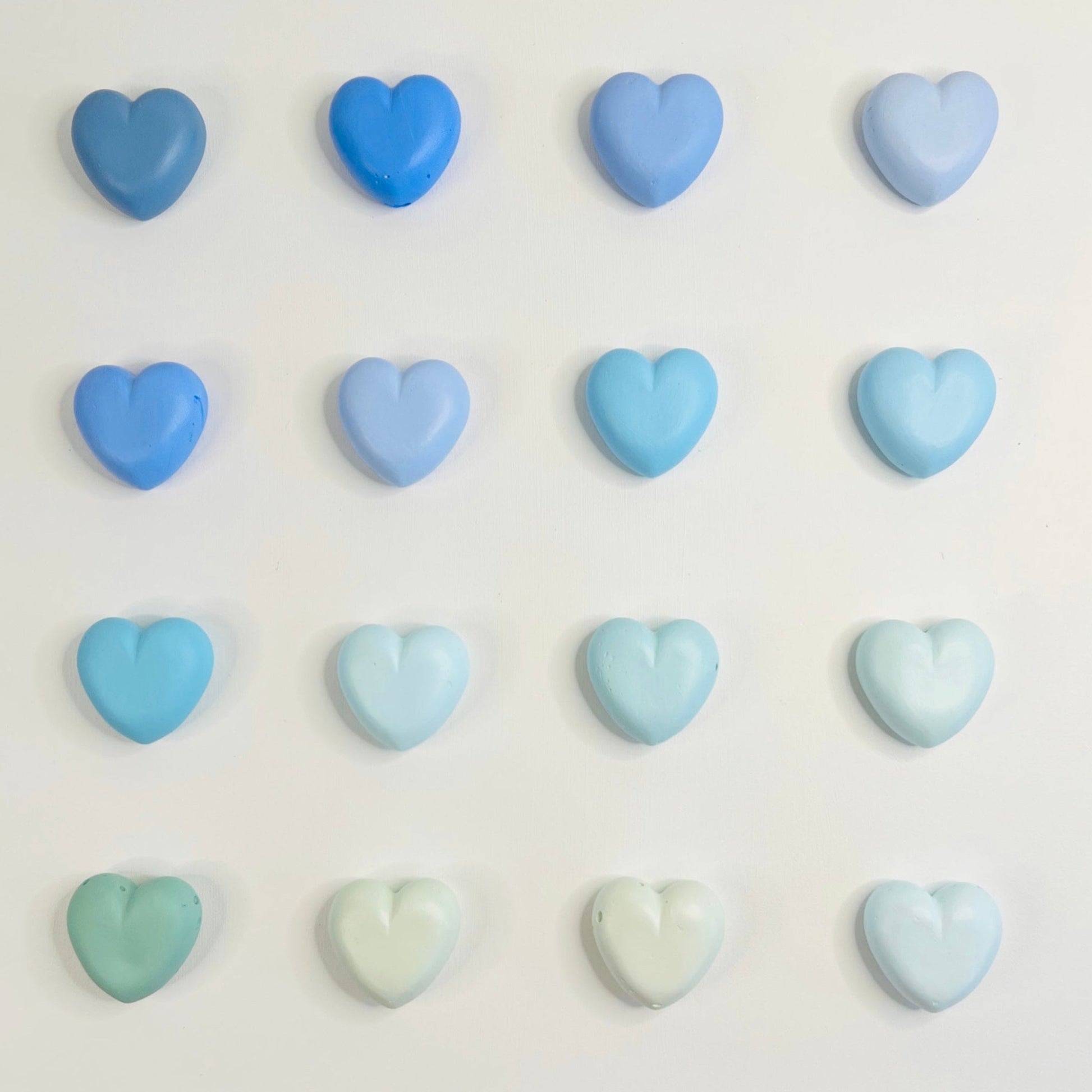 Pastel blue and green heart-shaped candies on a white background