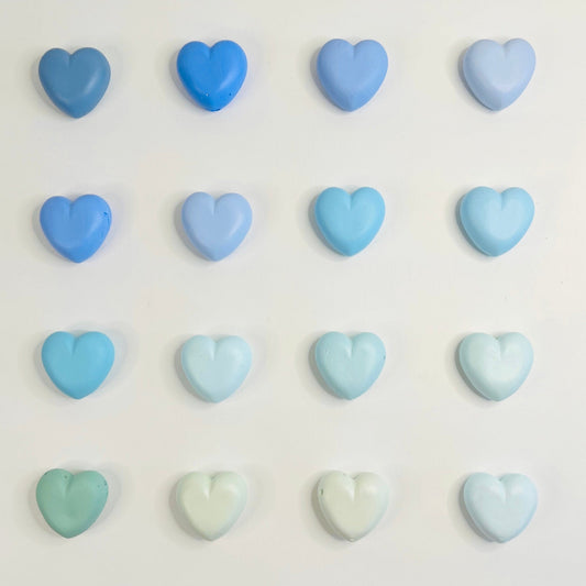 Pastel blue and green heart-shaped candies on a white background