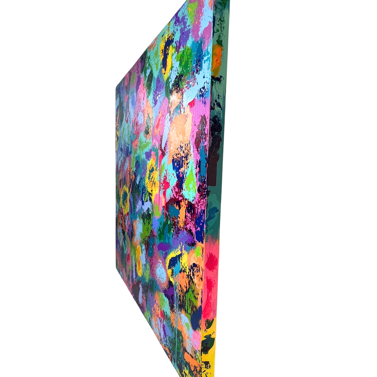 A square abstract canvas print shown at an angle, featuring a vibrant, multicolored paint-splattered pattern with prominent shades of pink, blue, green, yellow, and purple on a white background.