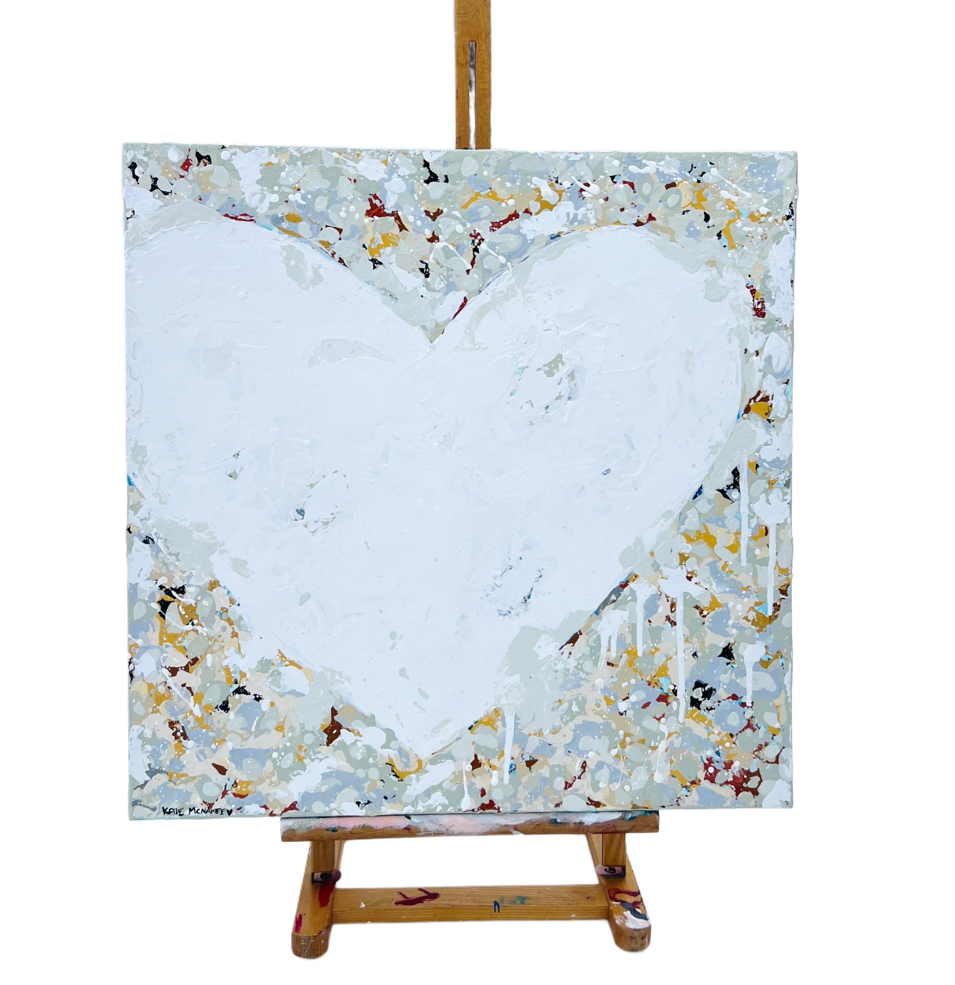 Heart-shaped painting on an easel with a white background