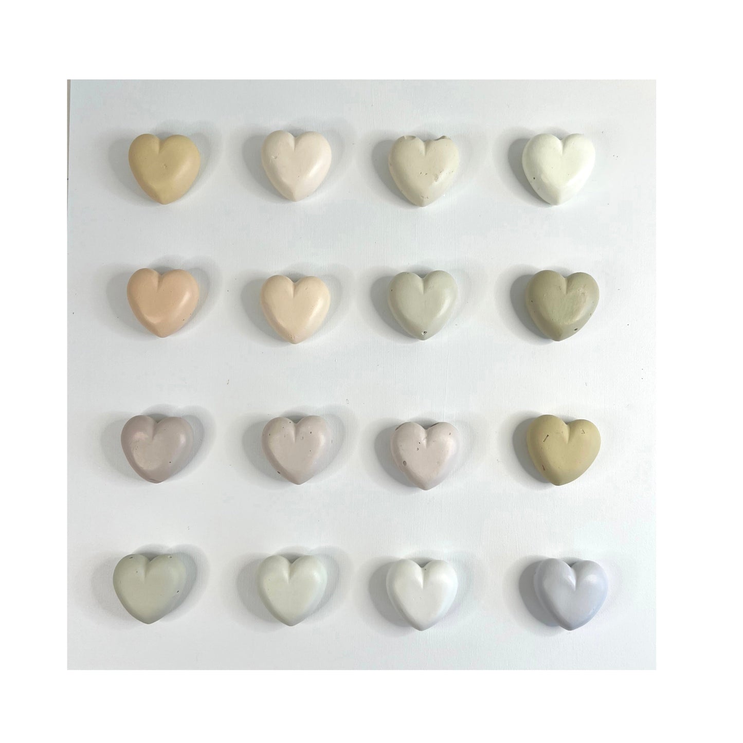 Set of heart-shaped ceramic tiles in various colors on a white background