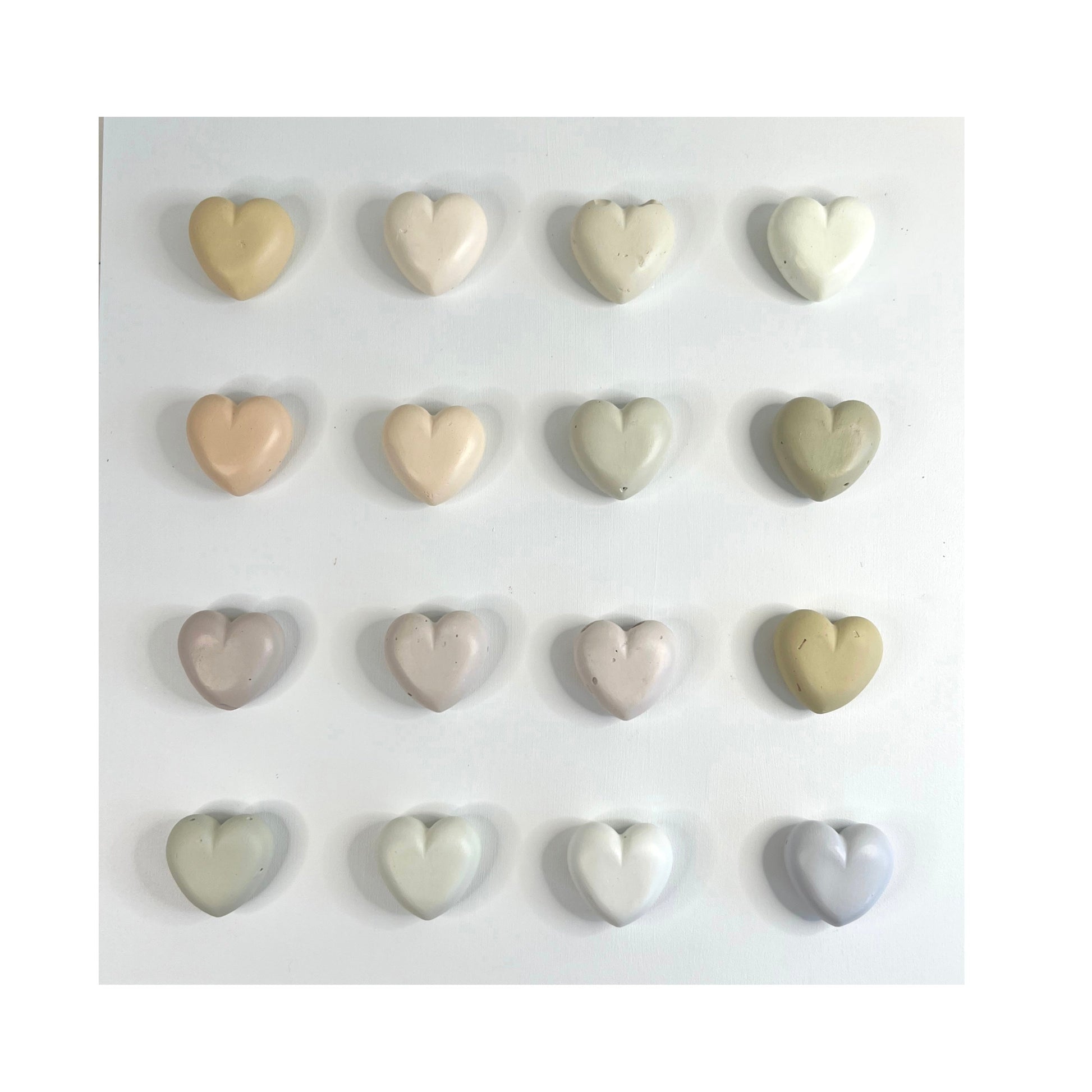 Set of heart-shaped ceramic tiles in various colors on a white background