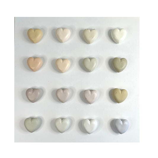 Set of heart-shaped ceramic tiles in various colors on a white background