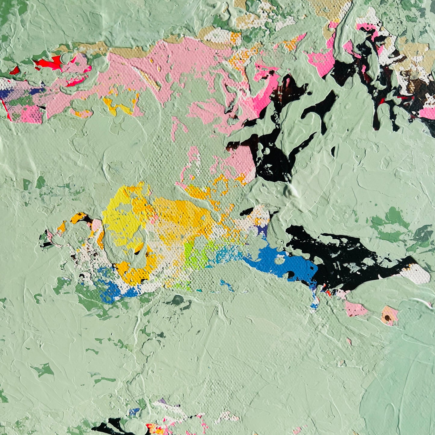 Abstract art with splashes of pink, yellow, blue, and black on a textured green background