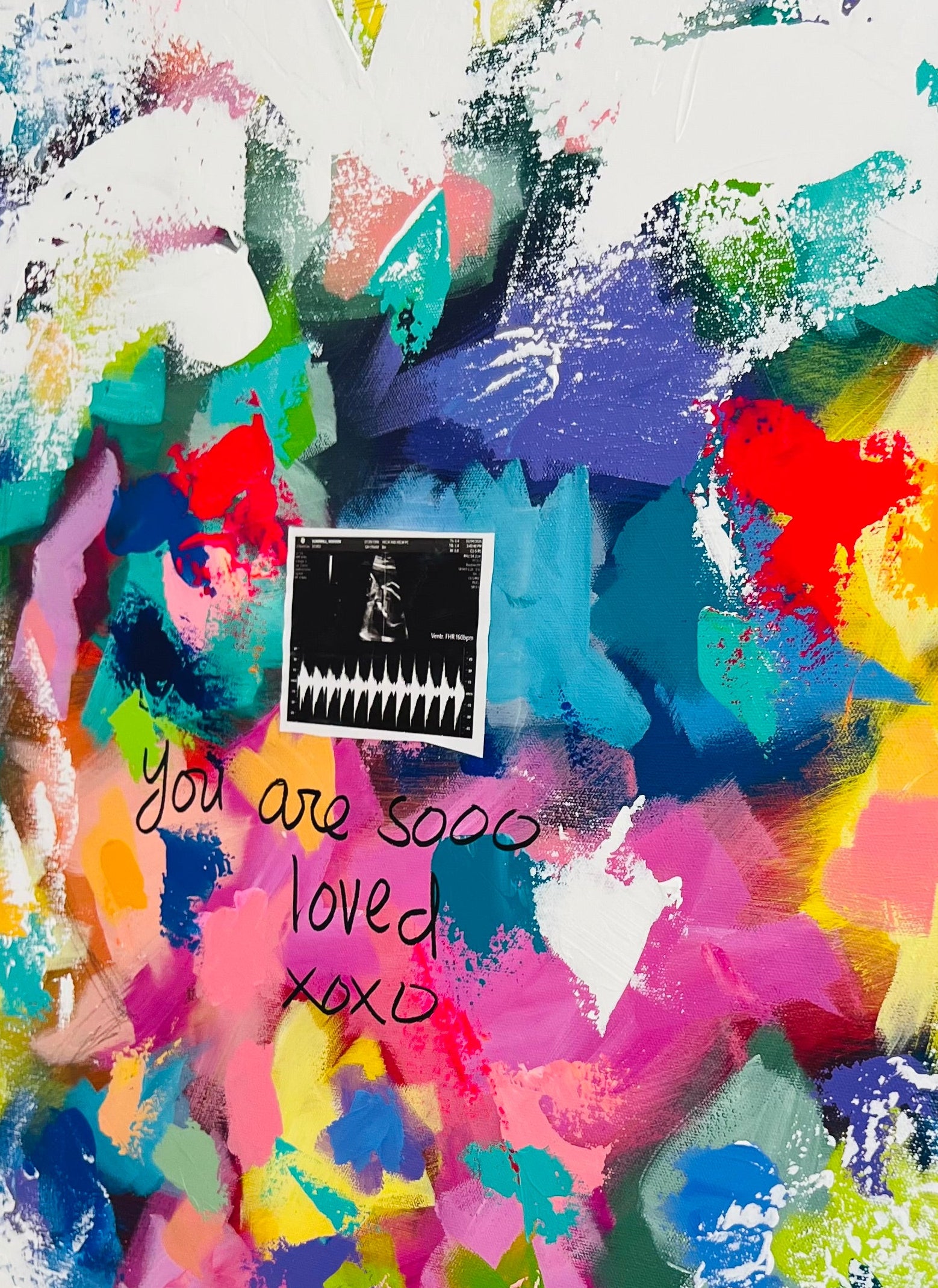Colorful abstract heart-shaped painting with text on a white background