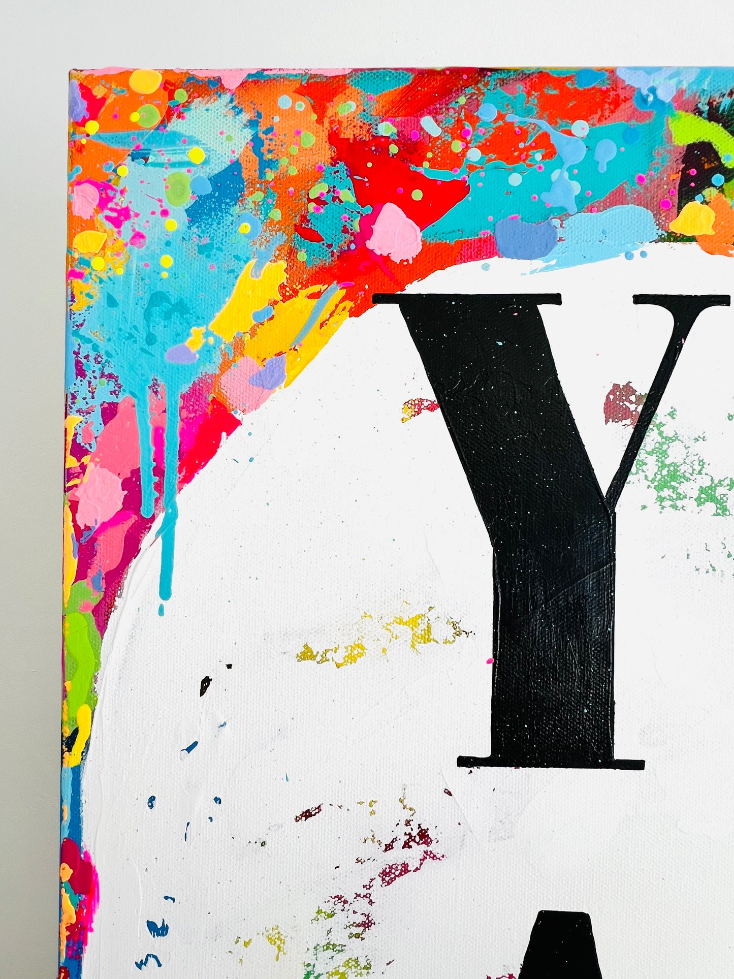 Colorful abstract painting with a large black letter 'Y' on a white background