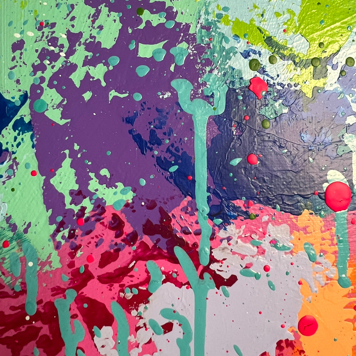 Abstract colorful paint splatter artwork with green, purple, pink, orange, yellow, blue, and red drips and splashes across the full frame.