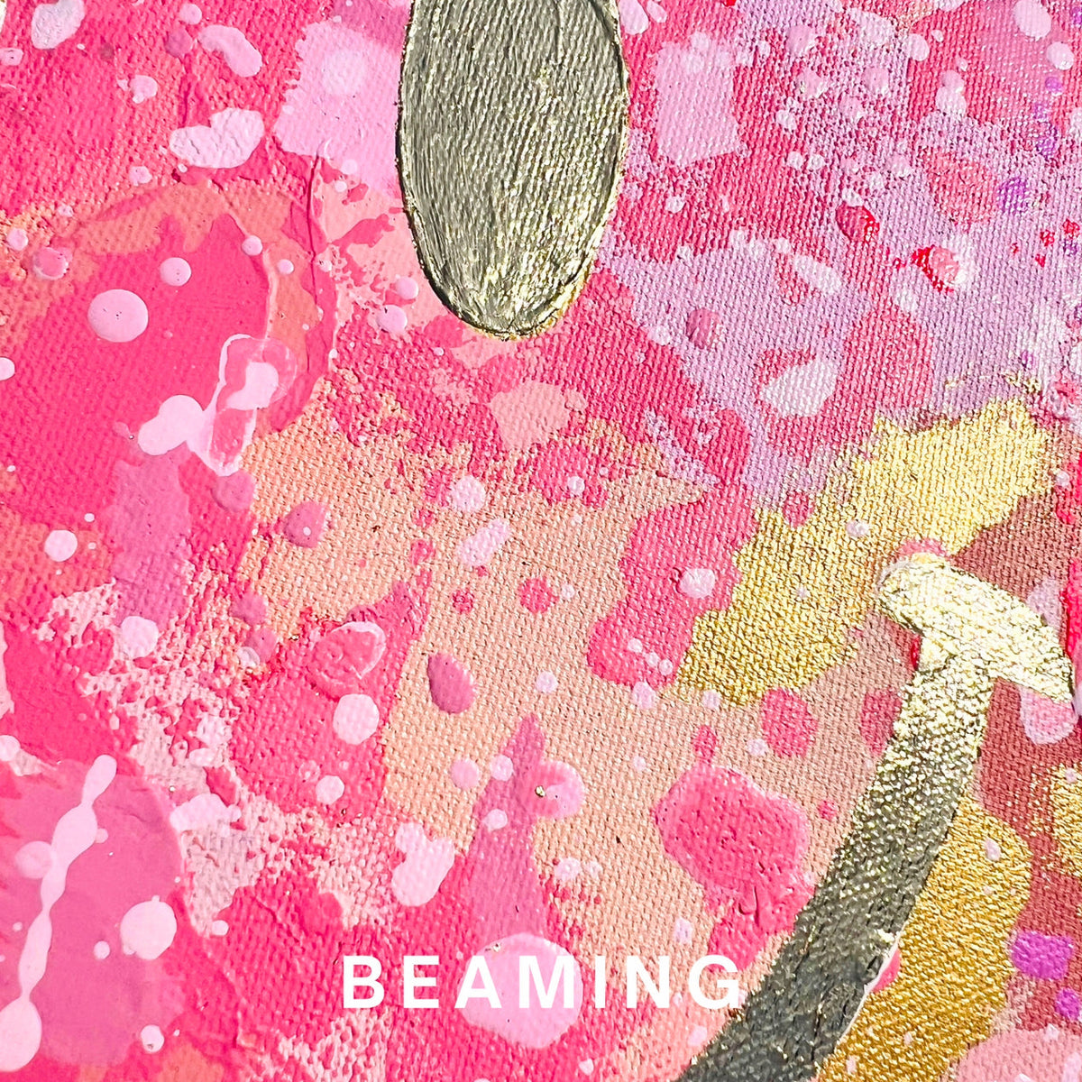 A close-up of a pink and peach textured fabric with splattered paint details, metallic gold leaf accents, and the word 'BEAMING' printed in white at the bottom.