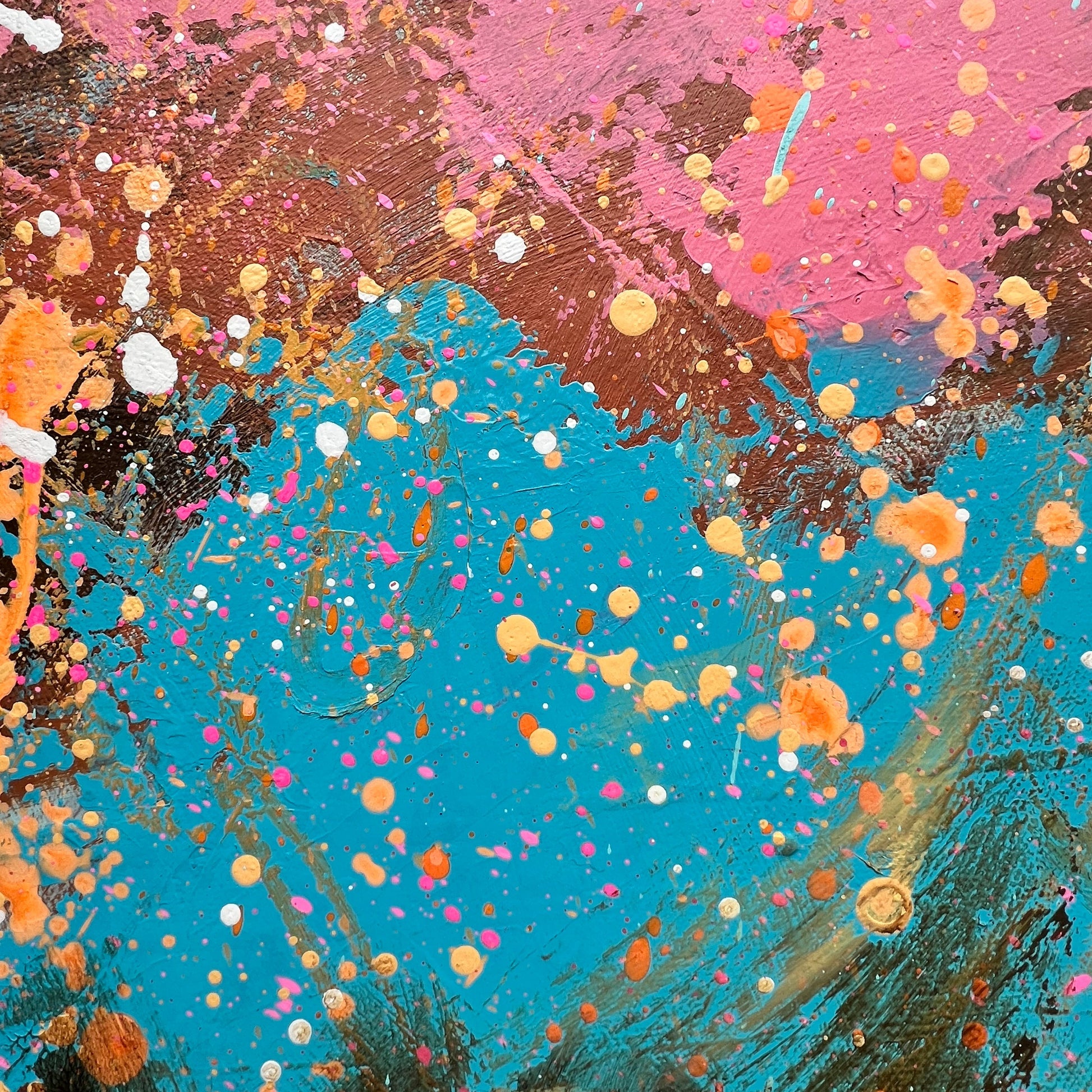 Abstract art with splashes of pink, blue, and orange on a textured background