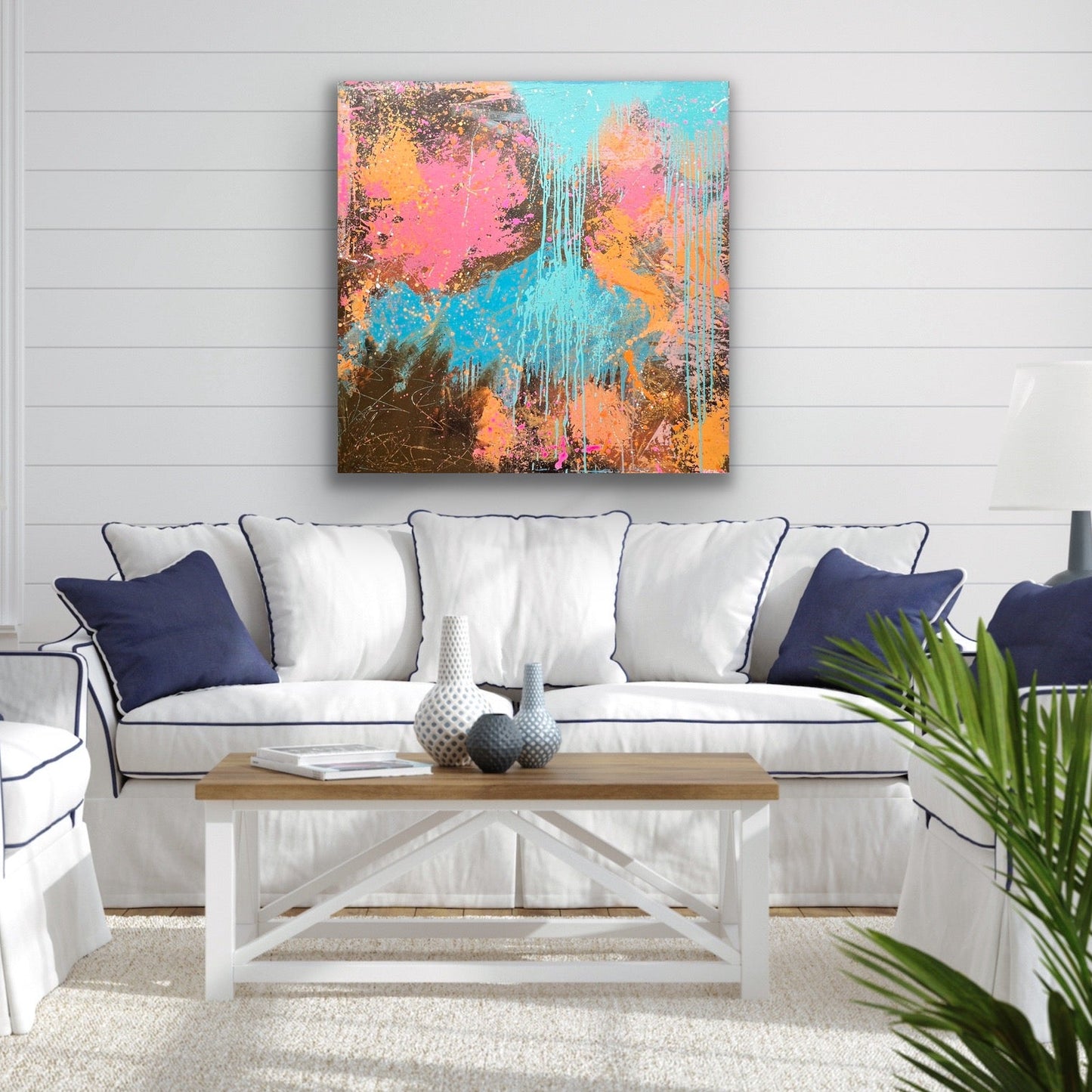 Living room with a colorful abstract painting on the wall, white sofa, and wooden coffee table.