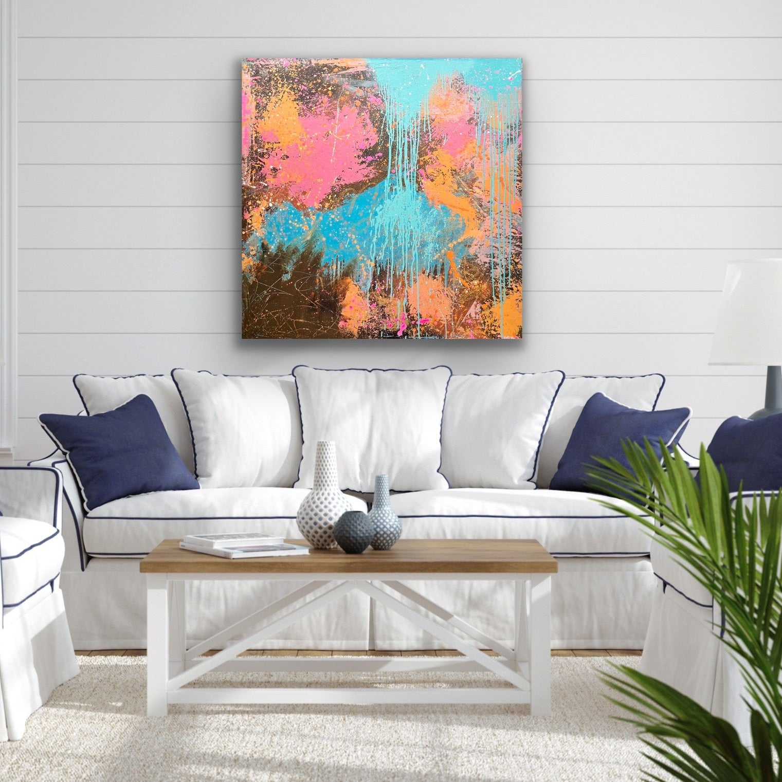 Living room with a colorful abstract painting on the wall, white sofa, and wooden coffee table.