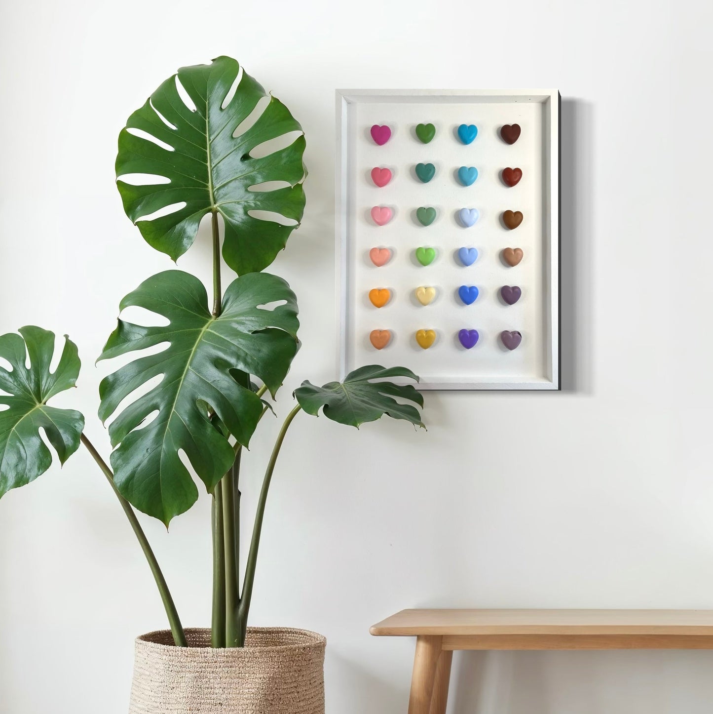 Potted plant next to a wall with a colorful heart art piece and a wooden bench.