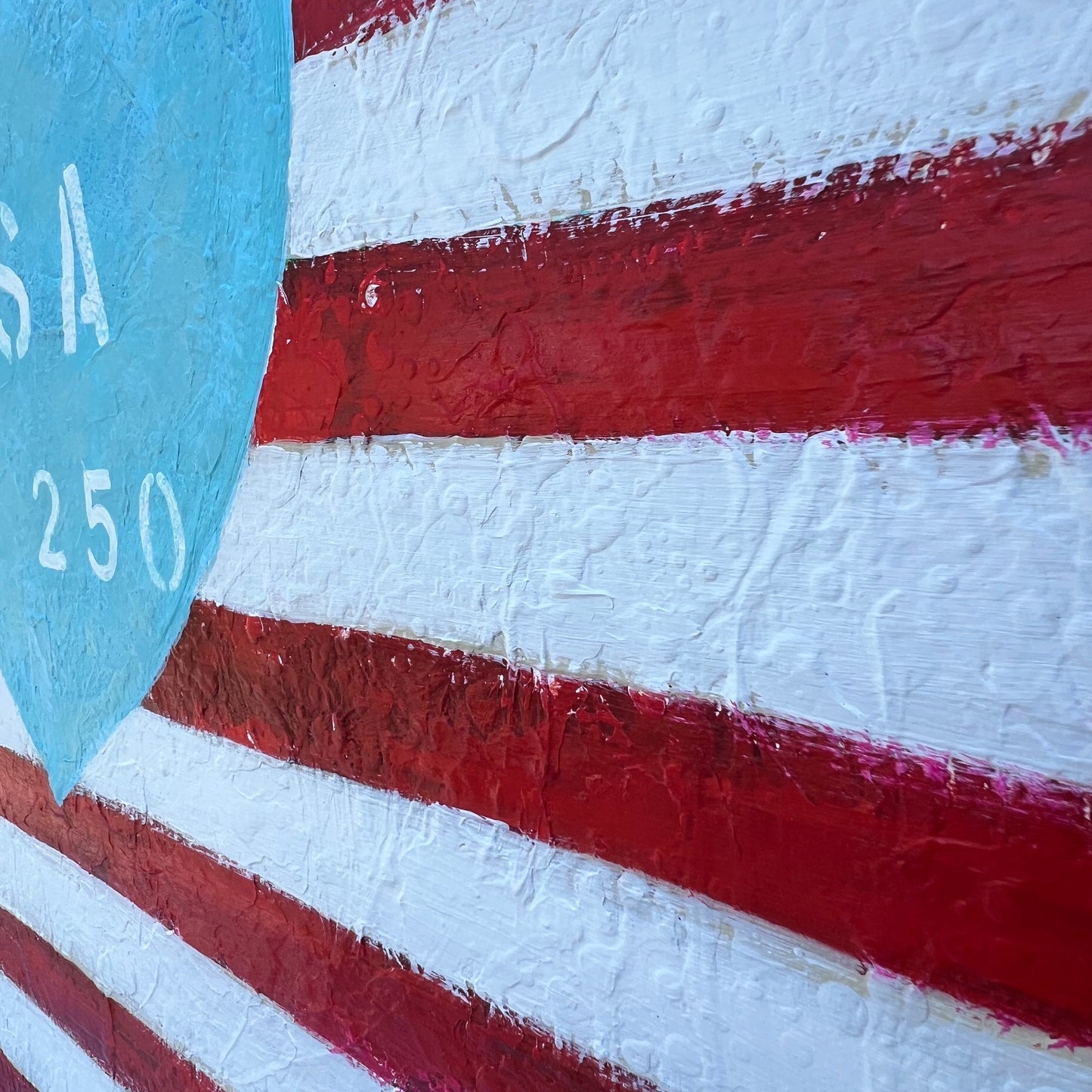 Close-up of a red and white striped surface with a blue object in the foreground.