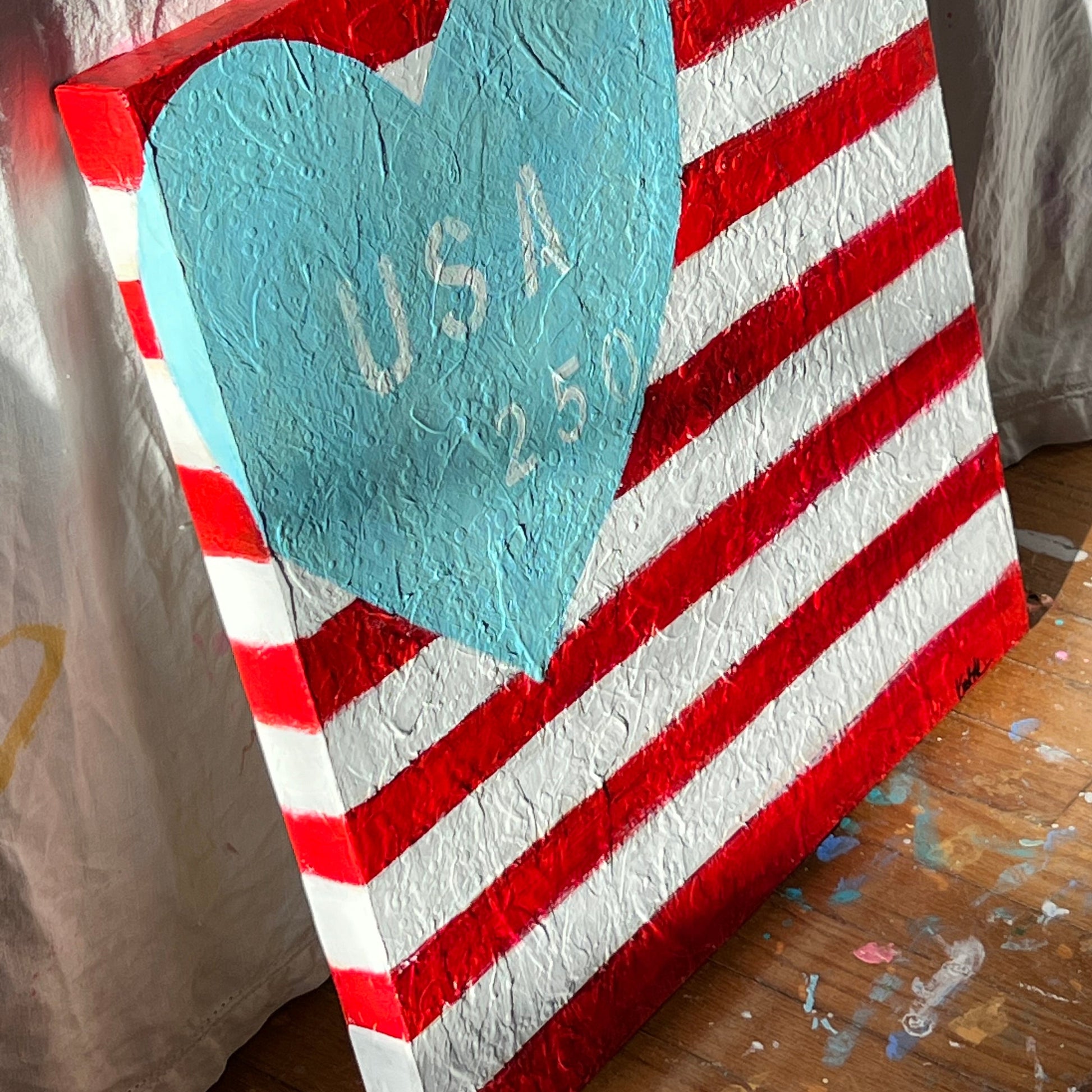 Red and white striped mat with a blue heart and text on a wooden surface.