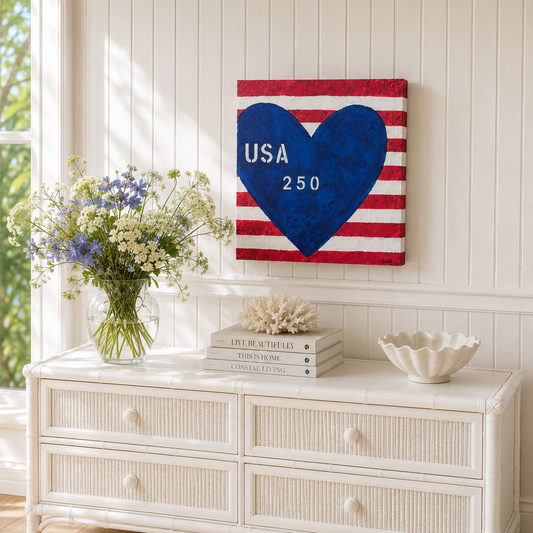 Decorative wall art with heart and 'USA 250' on a striped background above a white dresser.
